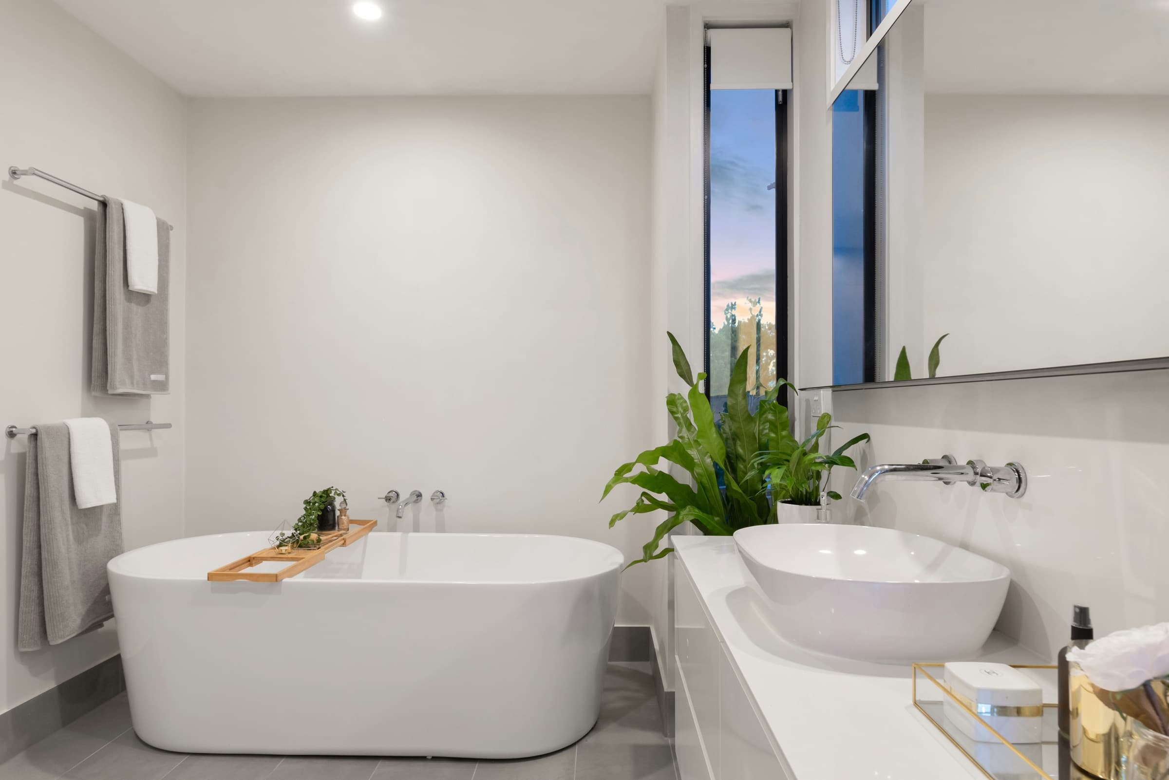 Modern luxury bathroom with white freestanding bathtub and walk-in glass shower